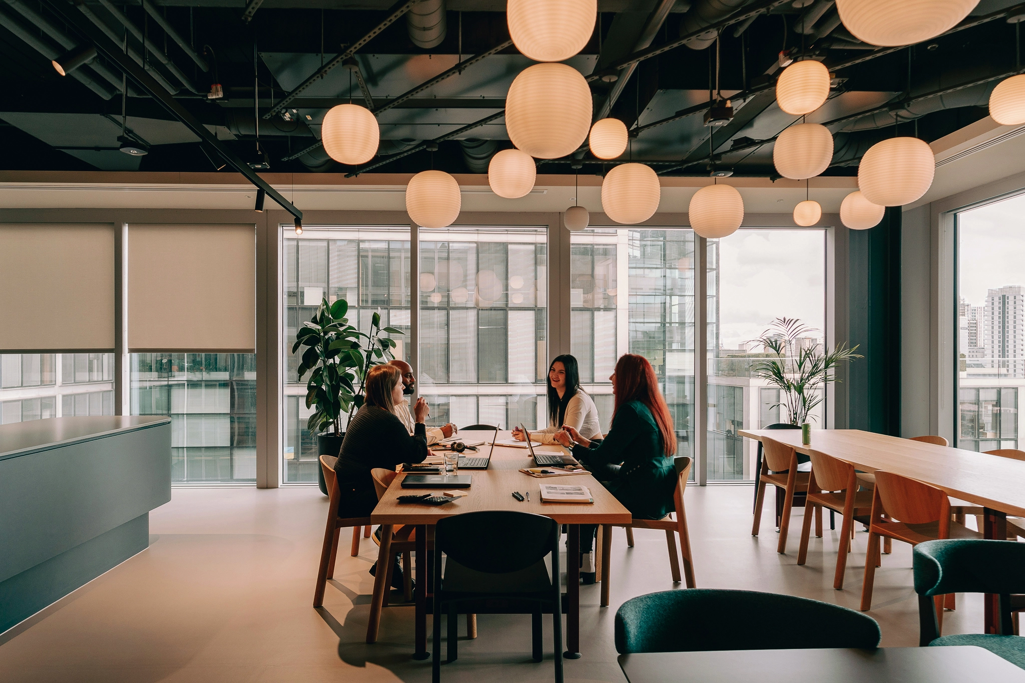 people sitting at a table under round overhead lights
